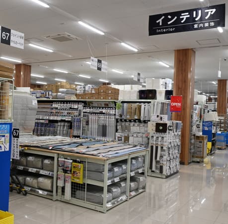 コーナン店内のインテリア売り場全体と、その奥に並ぶカーテンコーナーの様子